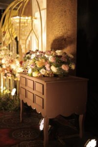 Rustic drawer table with floral arrangements at wedding entry decor