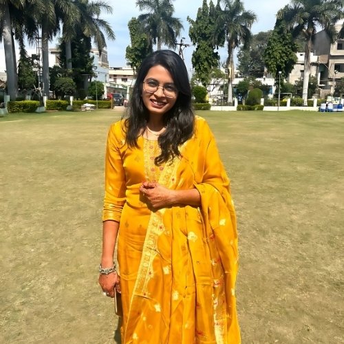 Ruchi Choudhary in a bright yellow traditional dress standing on a lawn