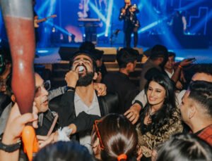 Guests enjoying a lively wedding sangeet party with live music and dance