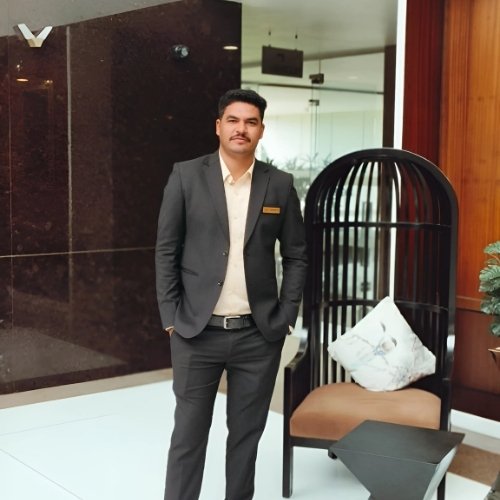 Pankaj Goyal in formal suit standing confidently in modern office lounge