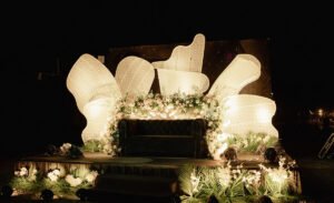 Wedding stage with floral arrangement and elegant lighting.