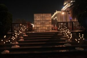 Elegant nighttime wedding entrance with candlelight decor and illuminated backdrop