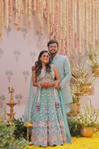 Bride and groom posing at a wedding celebration with floral decorations.