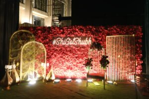 red floral wedding backdrop with #ShiGotShubh sign