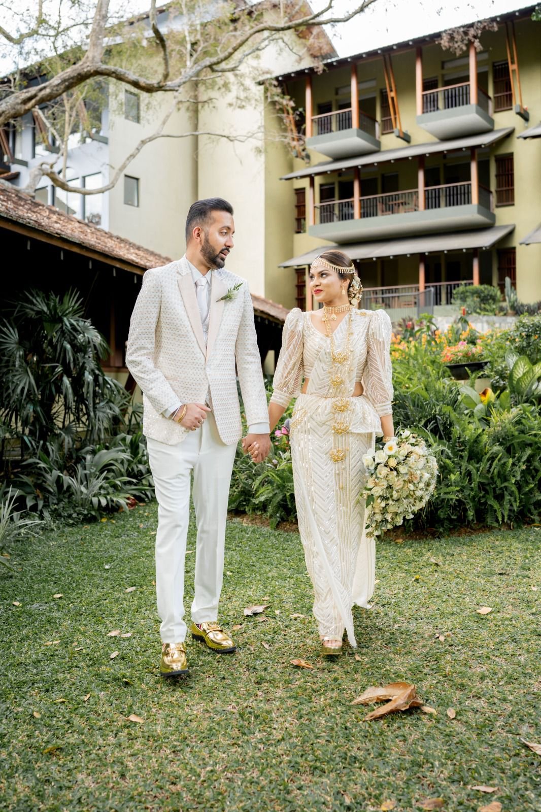 bride and groom walking hand in hand in lush garden wedding venue